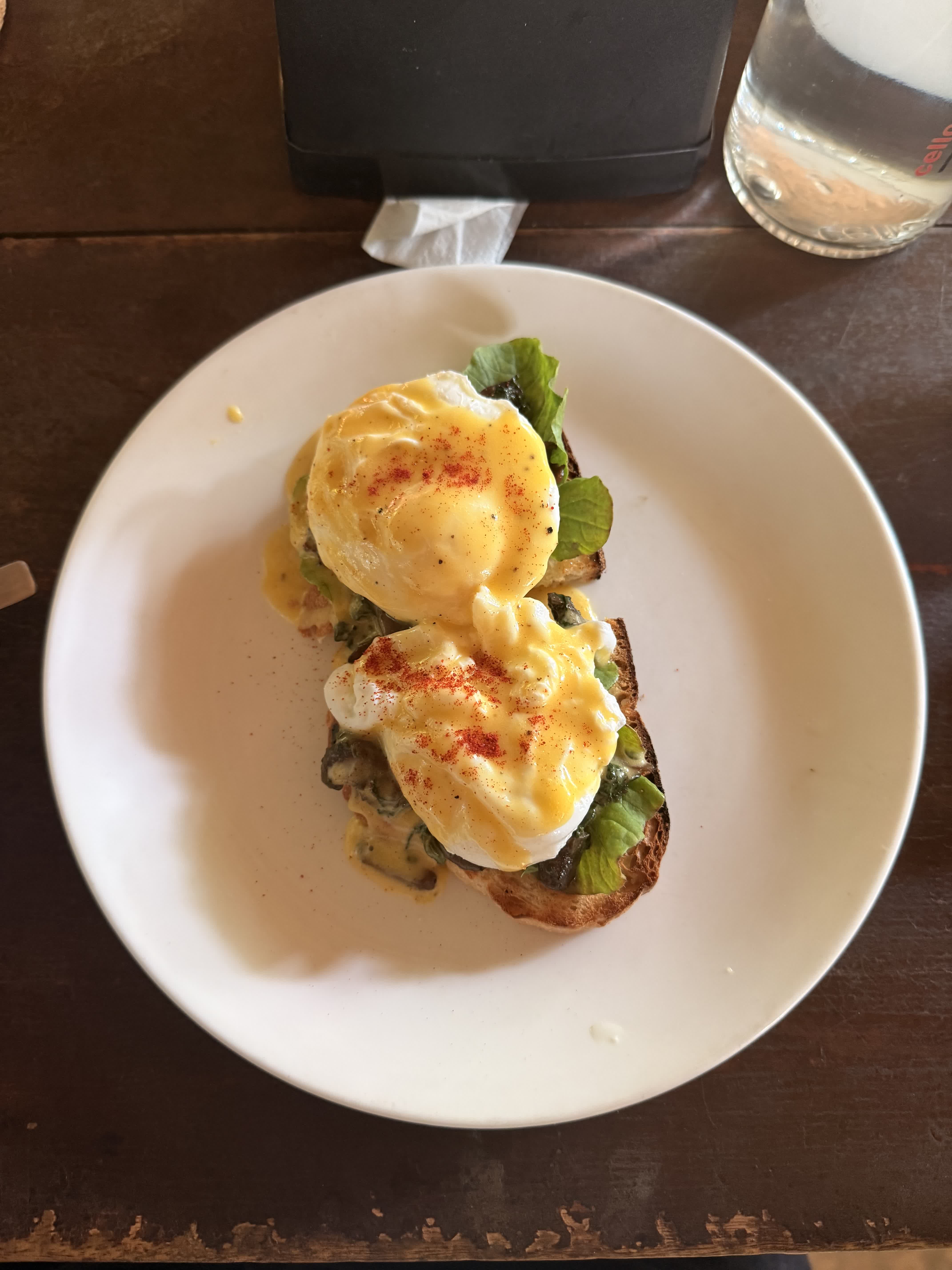 A plate of eggs Benedict on toasted sourdough