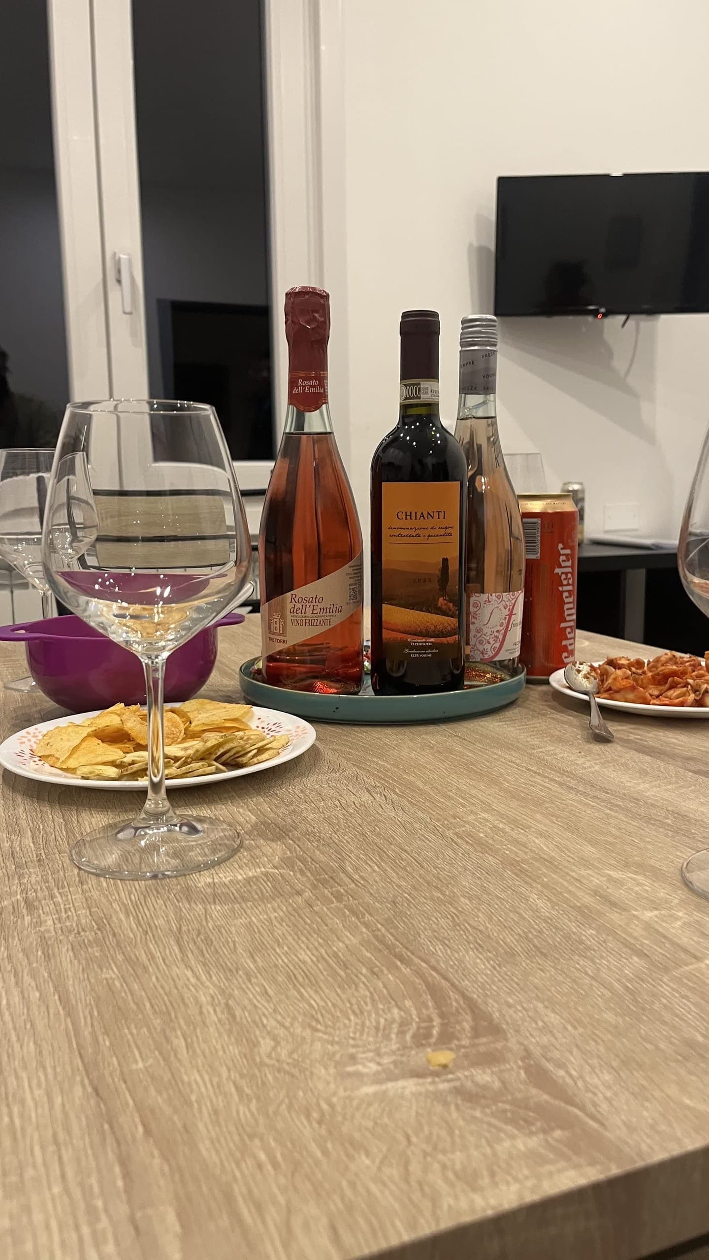 Bottles of Italian wine and snacks on a table at night