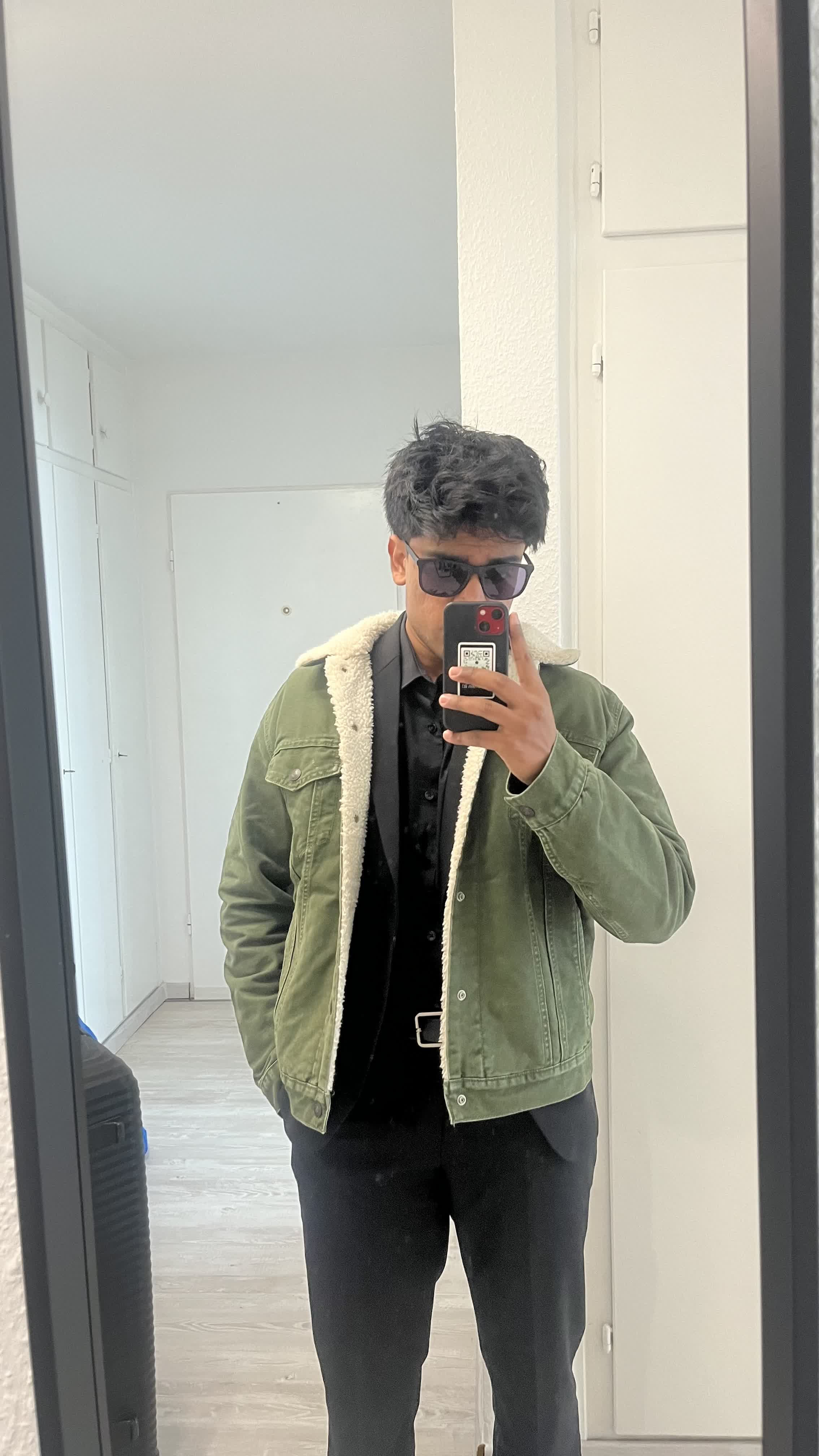 Mirror selfie in a sherpa-lined green jacket and sunglasses