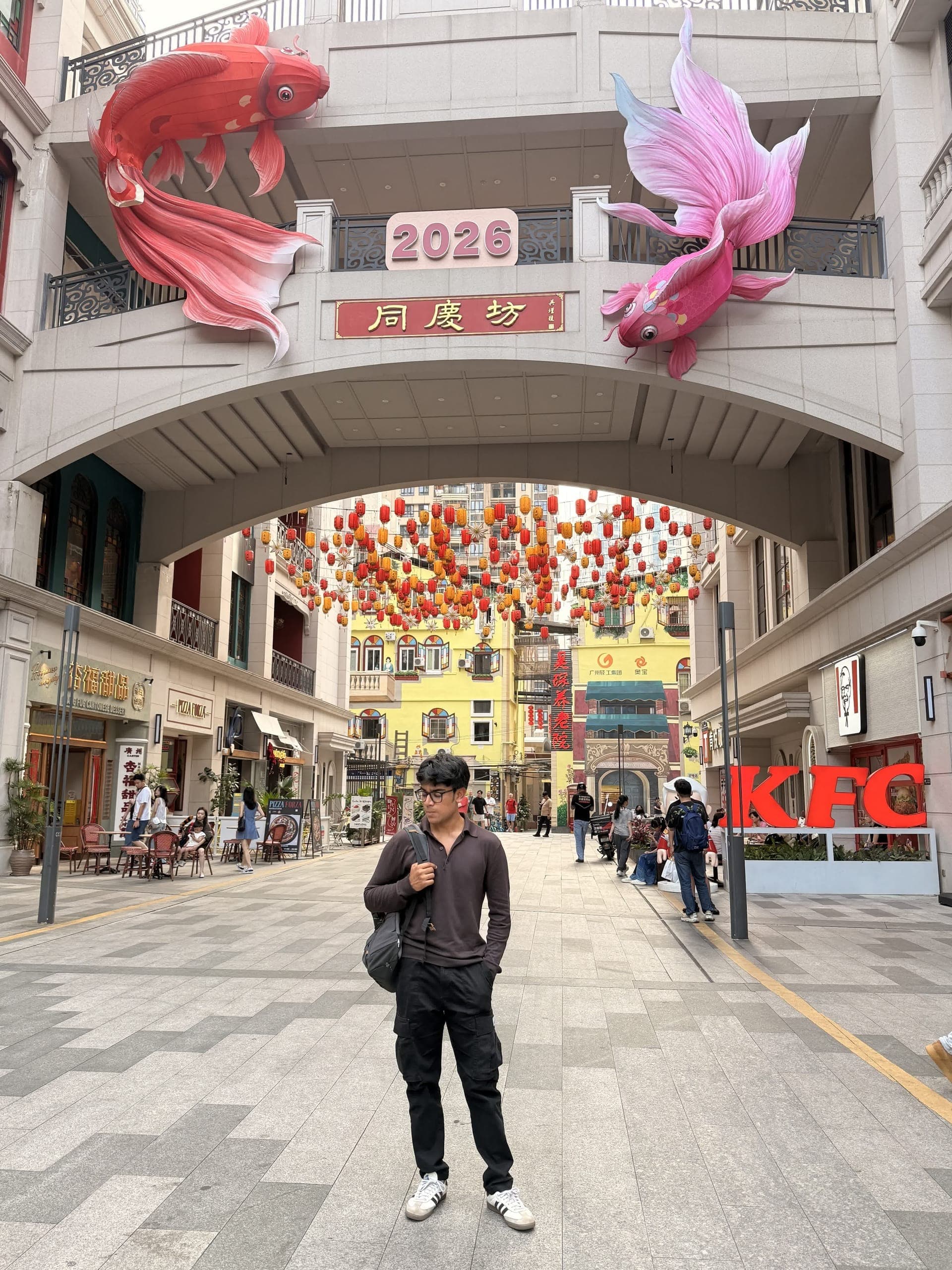 Standing under giant koi sculptures and red lanterns at the Tongqingfang arch